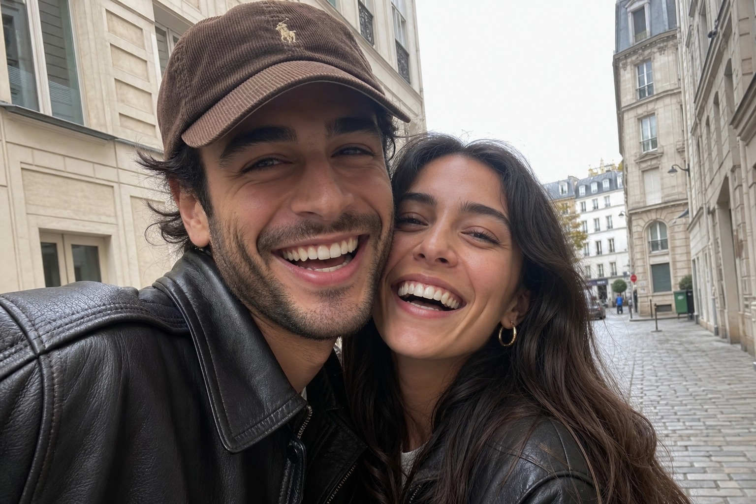 The same couple laughing together on a cobbled street