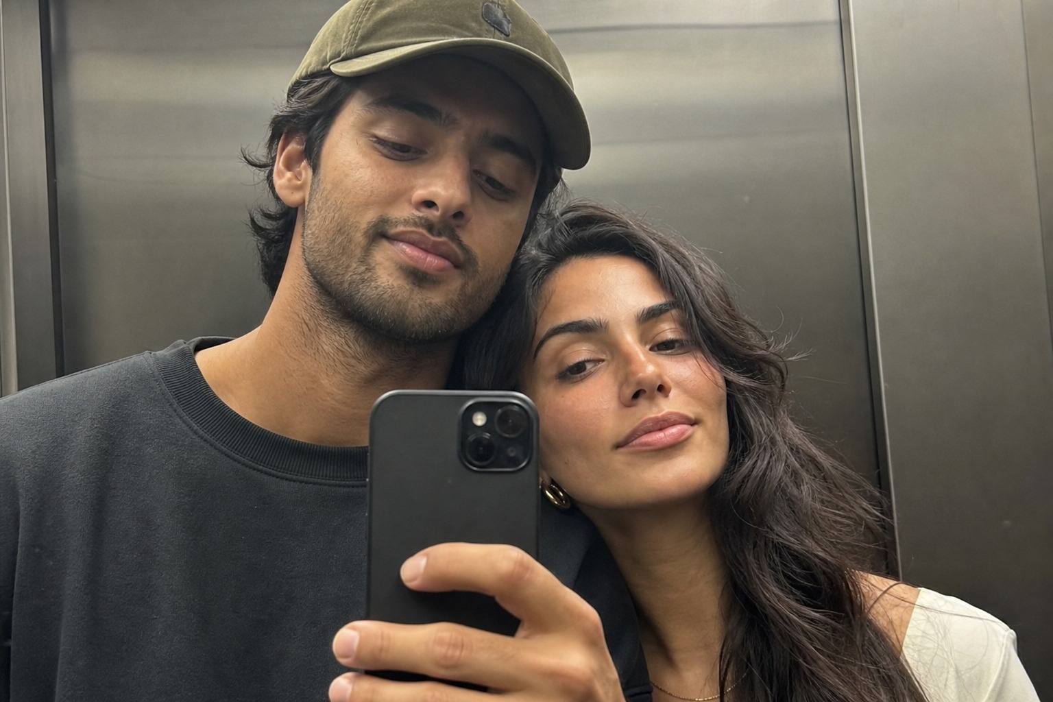 The couple in an elevator mirror selfie